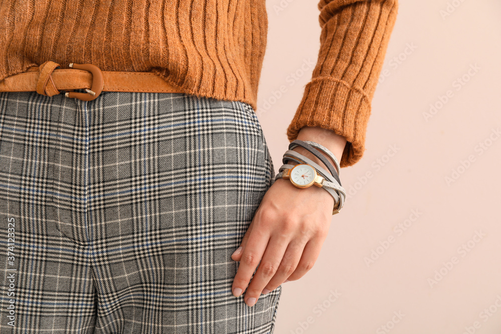 Woman with stylish wrist watch on color background, closeup