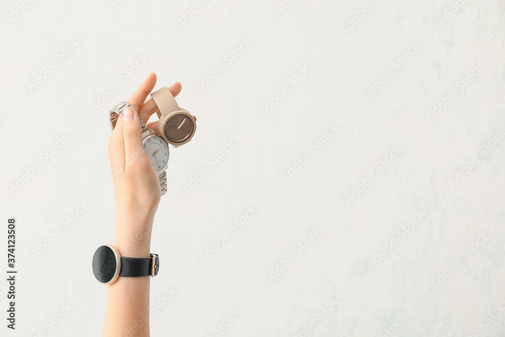 Female hand with stylish wrist watches on white background