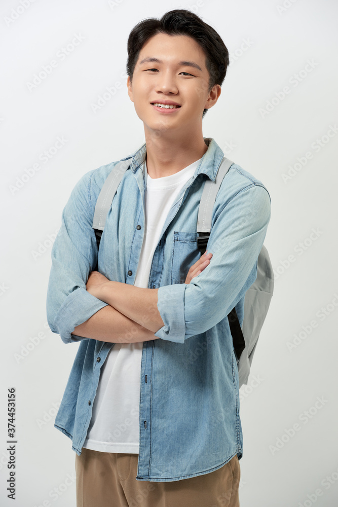 Portrait of happy young Asian man in casual with backpack over white background.