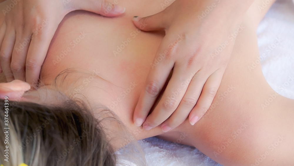 Relaxed woman getting back massage in luxury spa with professional massage therapist. Wellness, heal