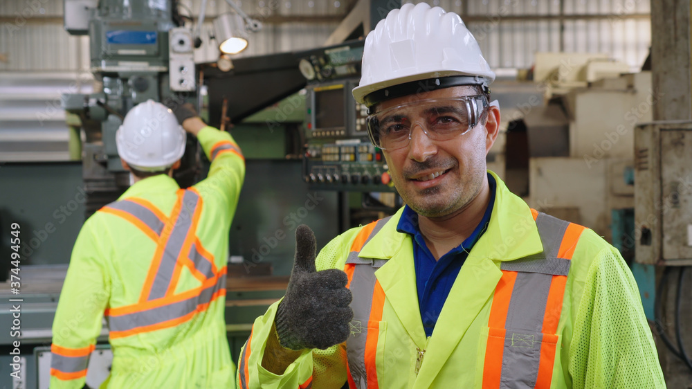 Young factory worker or engineer close up portrait in factory . Industry and engineering concept .