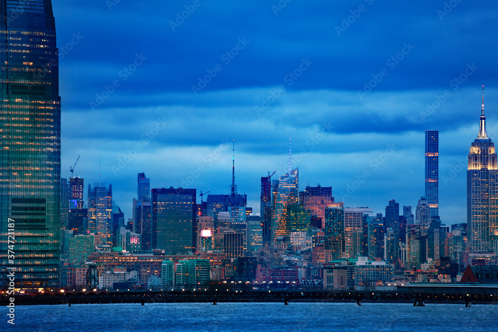 在阴云密布的夜晚，纽约曼哈顿市中心哈德逊河上的景色