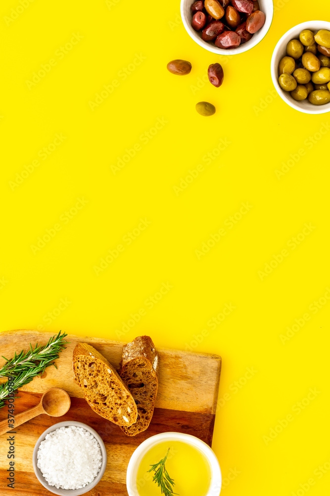 Appetizer. Olives in bowl and bread on cutting board from above space for text