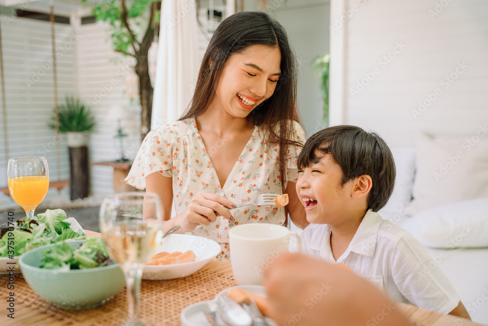 亚洲母子在餐厅一起吃健康食品。