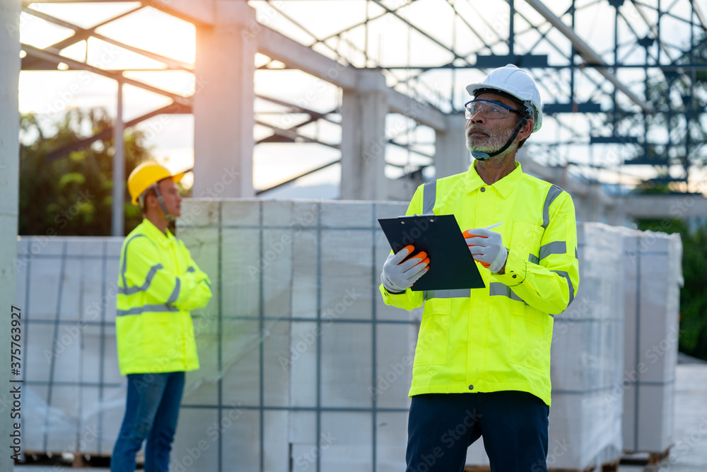 Construction manager and engineer working on construction site.