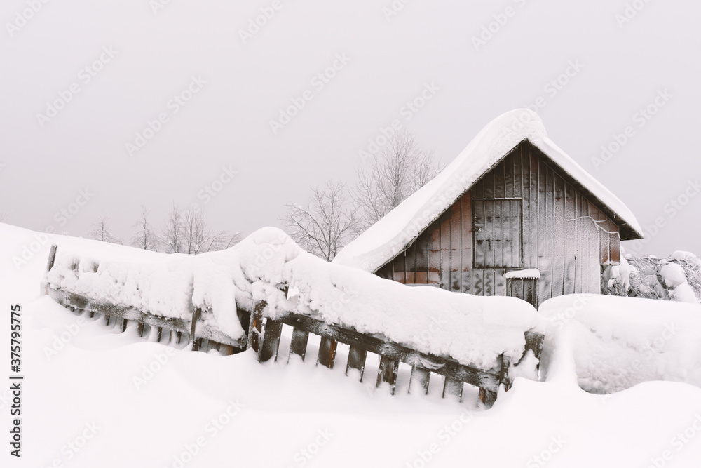 雪山木屋的极简主义冬季景观。多云，景观照片