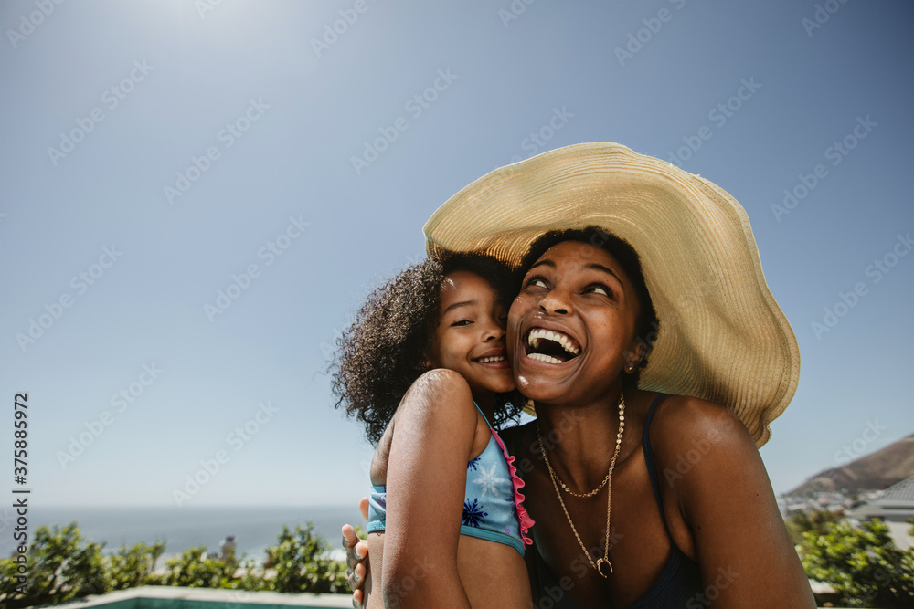 Woman with her daughter having fun at the pool