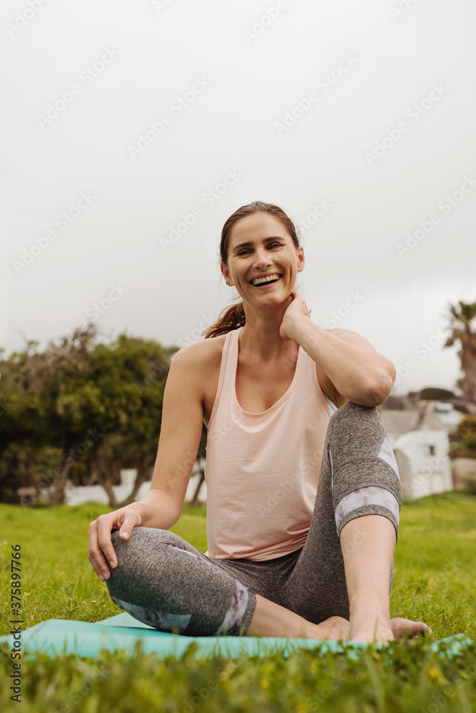 一个微笑的女人坐在公园里的肖像