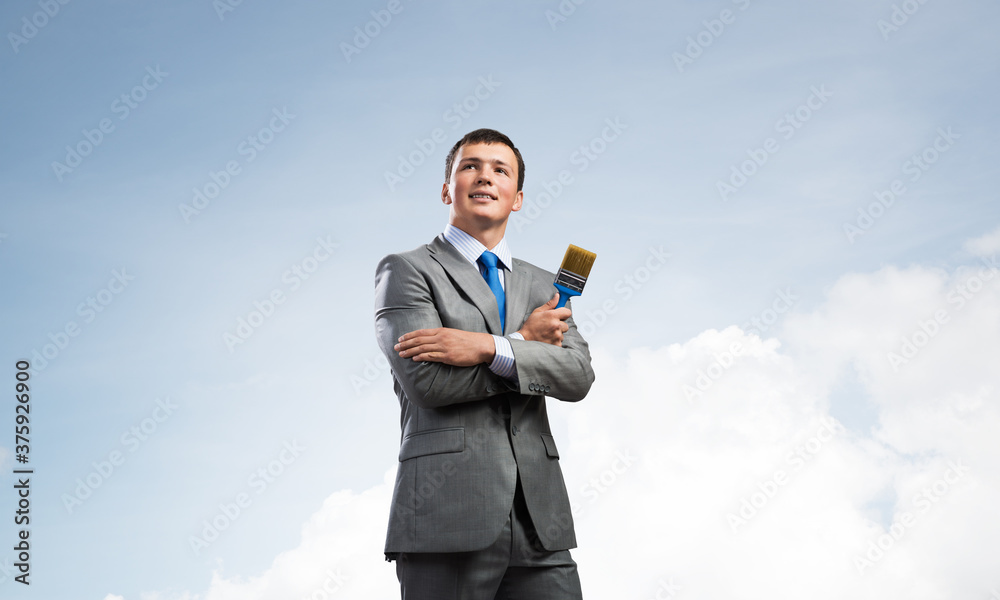 Creative businessman painter holding paintbrush