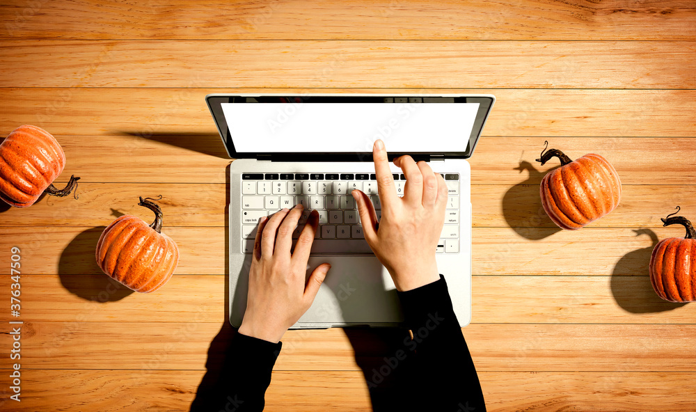 Autumn pumpkins with person using a laptop computer from above