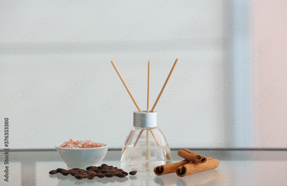 Reed diffuser, cinnamon, sea salt and coffee beans on table