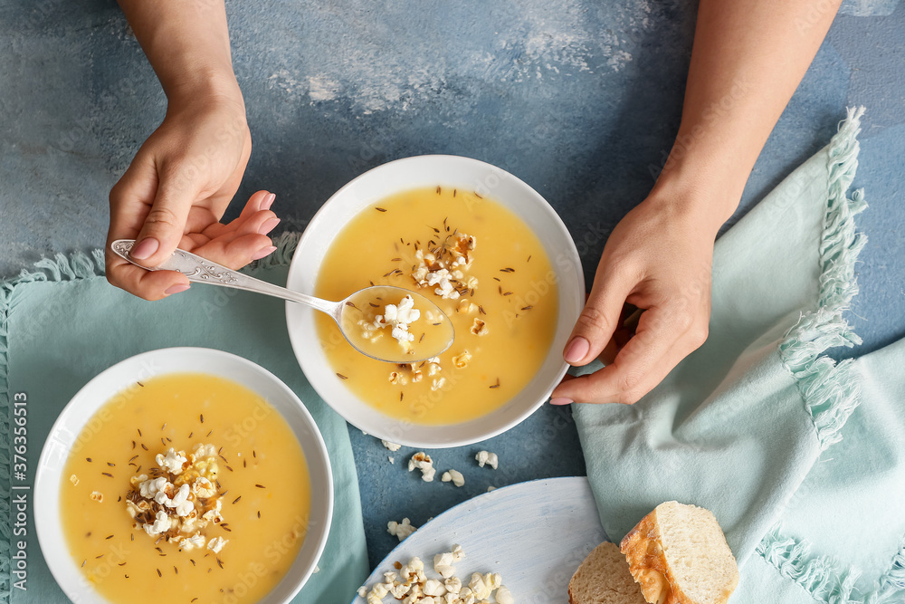 Woman eating tasty popcorn soup from bowl