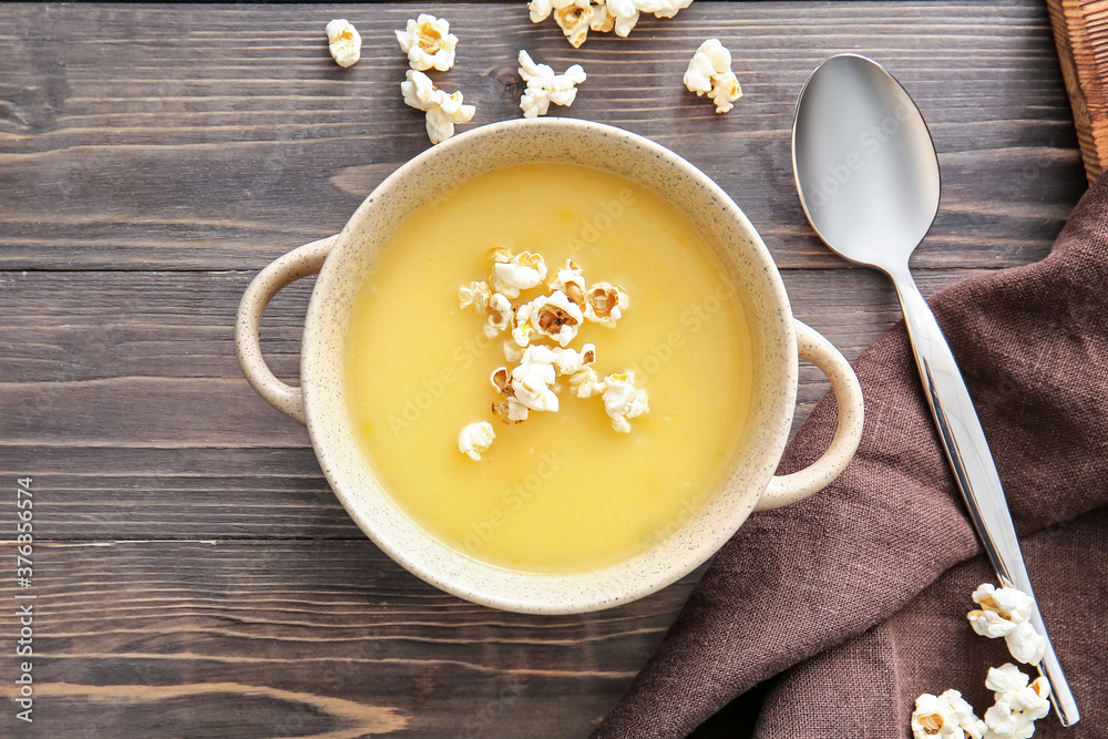 Pot with tasty popcorn soup on table