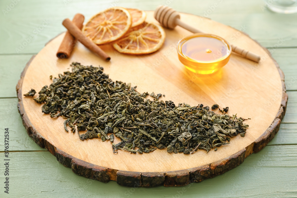 Dry tea leaves with honey and spices on table