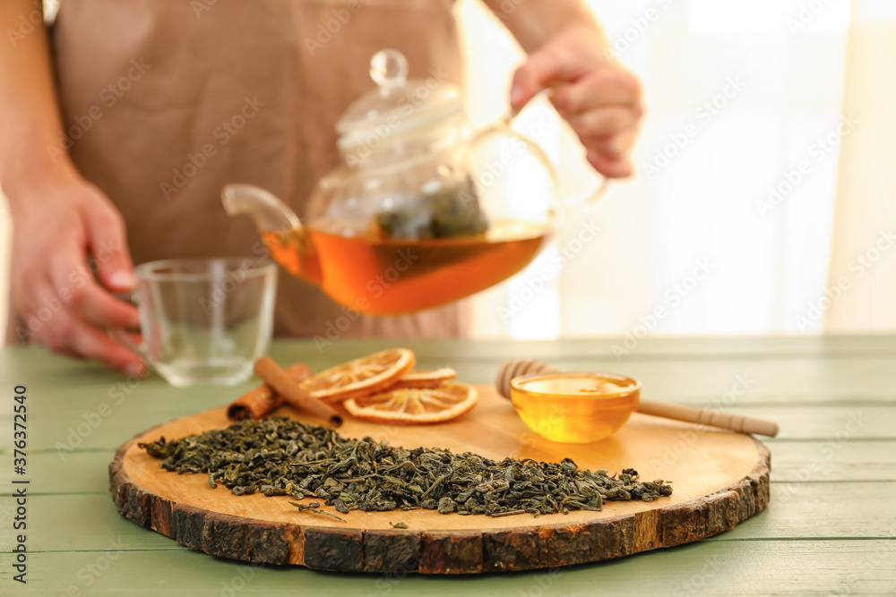 Dry tea leaves with honey and spices on table