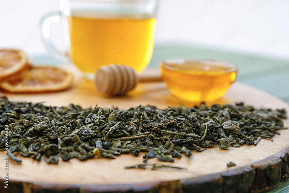 Dry tea leaves with honey on table, closeup