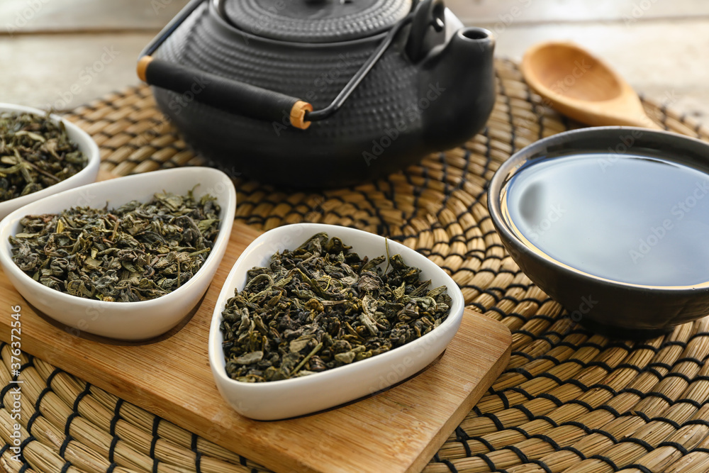 Cup of tea with teapot and dry leaves on table