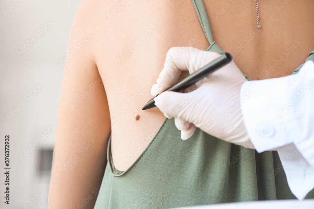 Dermatologist examining patient in clinic