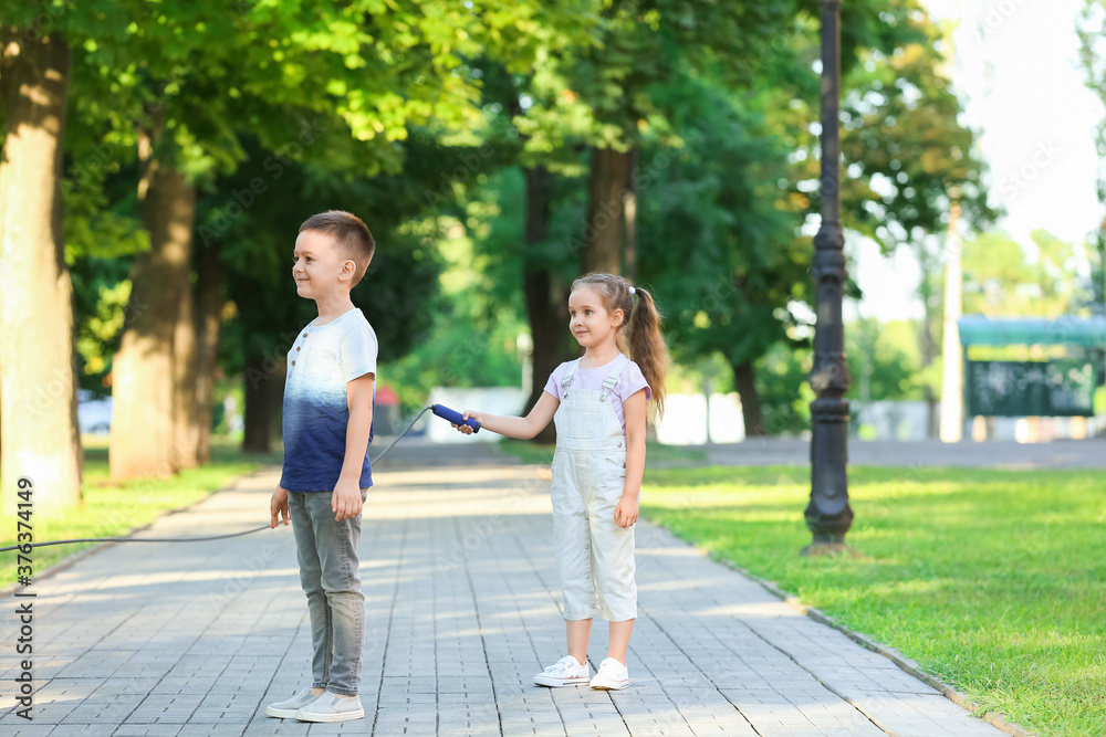 Cute little children jumping rope outdoors