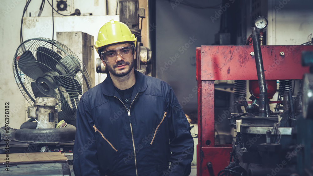 Young factory worker or engineer close up portrait in factory . Industry and engineering concept .