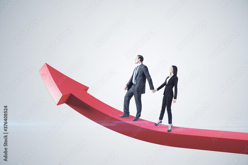 Businessman and businesswoman walking on red arrow