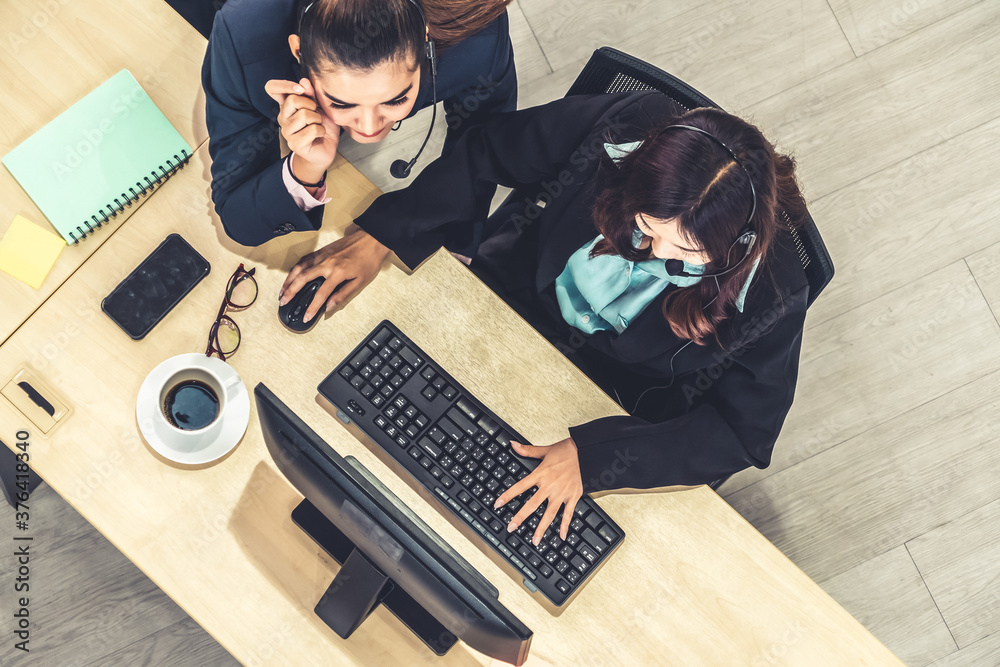 Business people wearing headset from top view in office working with computer to support remote cust