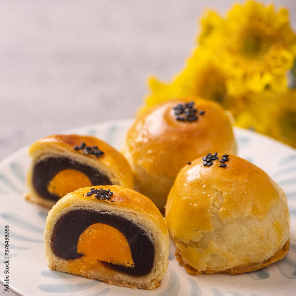 Tasty baked egg yolk pastry moon cake for Mid-Autumn Festival on bright cement table background. Chi