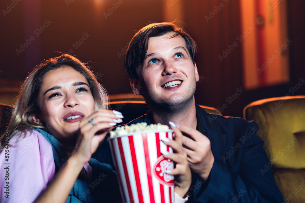 Caucasian lover enjoying to watch movie and eating popcorn together in the cinema