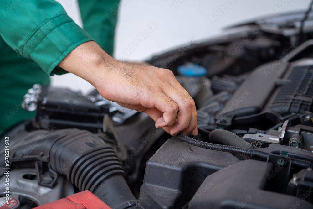 Professional mechanic hand providing car repair and maintenance service in auto garage. Car service 