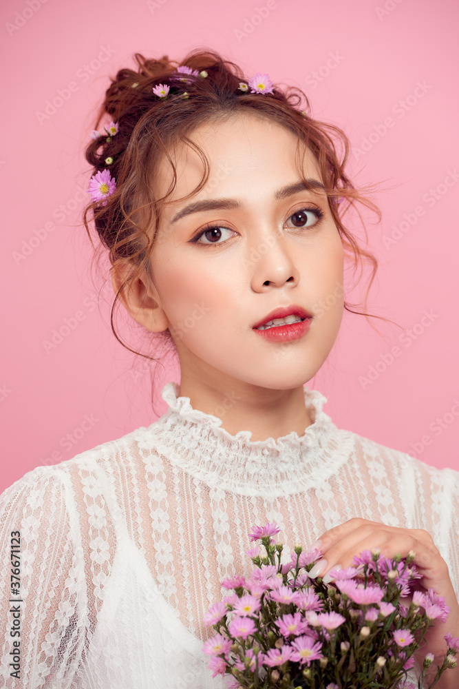 Pretty young lady with flowers looking at camera