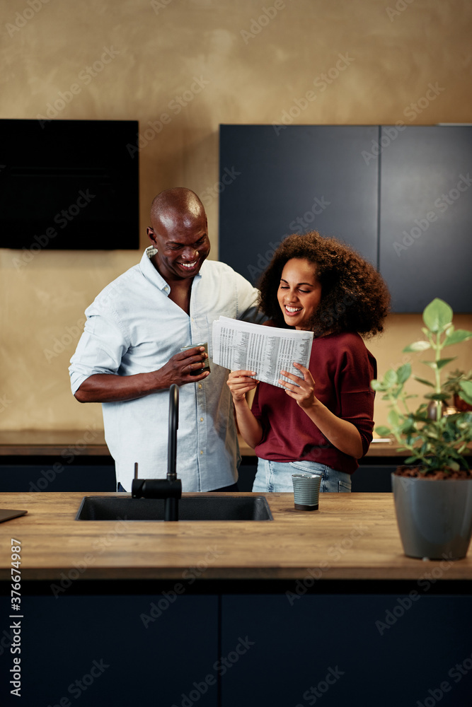 Smiling couple reading a newspaper together