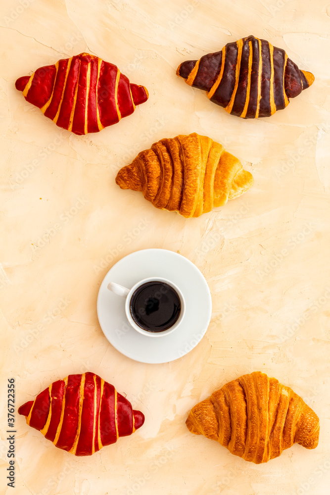 Set of coffee with croissants - chocolate, berry, classic - on stone table