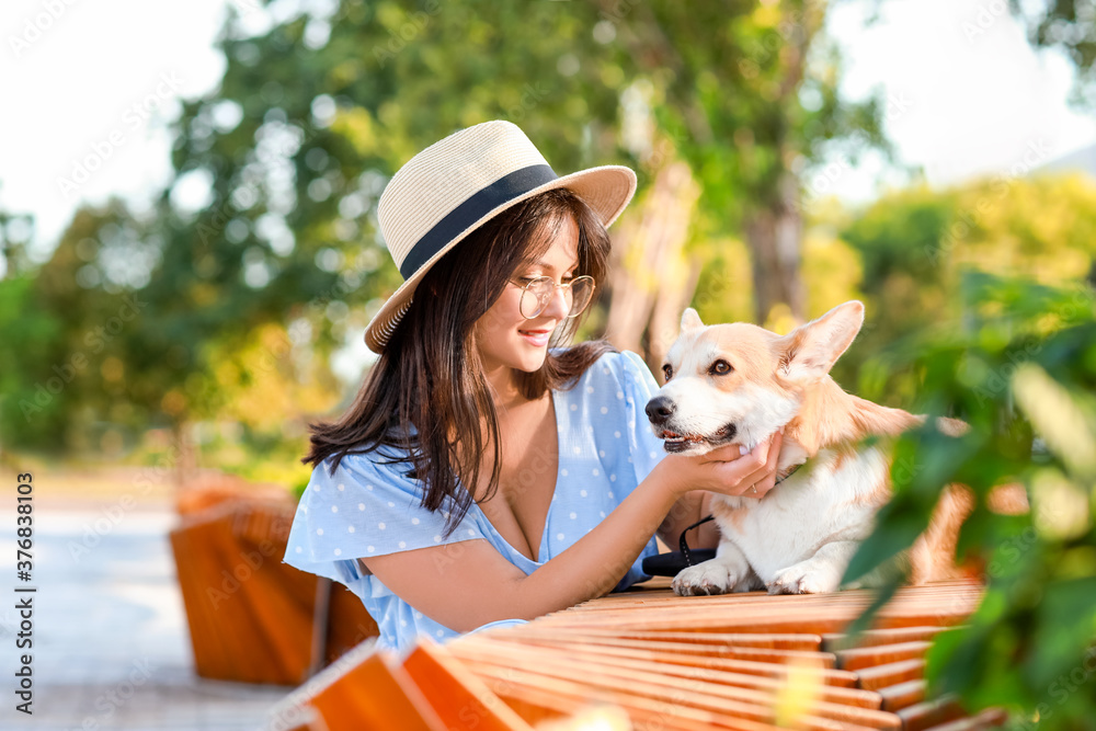 带着可爱的柯基犬在户外散步的女人