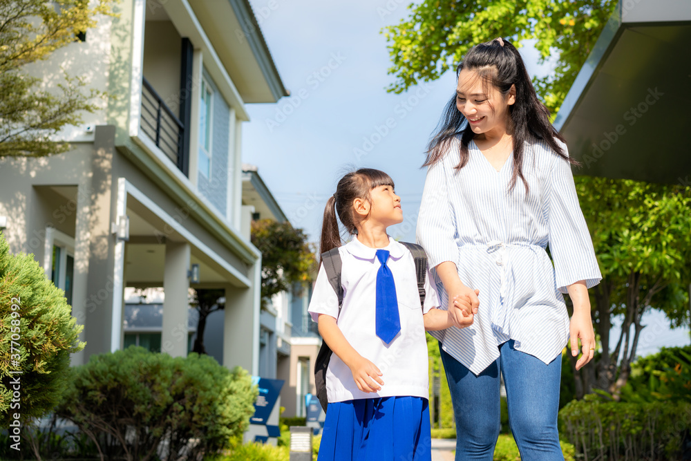 Happy Asian mother and daughter primary school student walking to school in the morning school routi