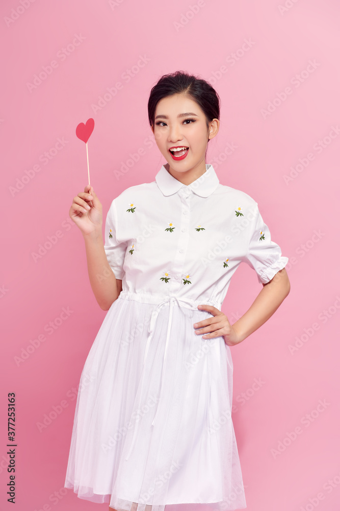 Romantic young woman with party decor for Valentines Day on pink background