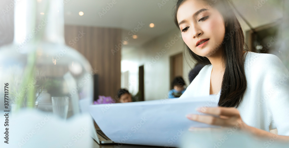 Asian young mother working at home using computer for working from distance whilestay quarantine tog