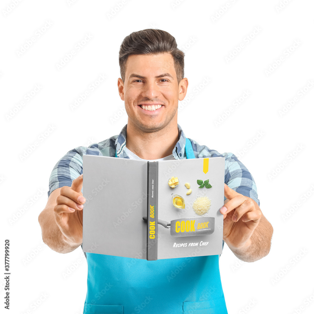 Young man with cook book on white background