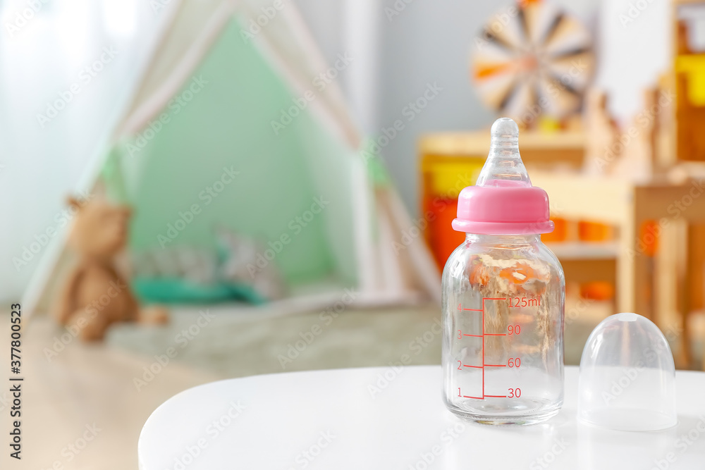 Baby bottle on table in room