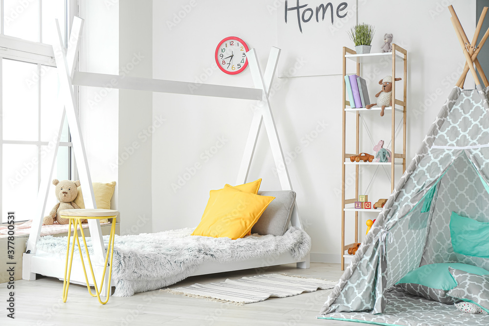 Interior of modern childrens room with play tent and bed