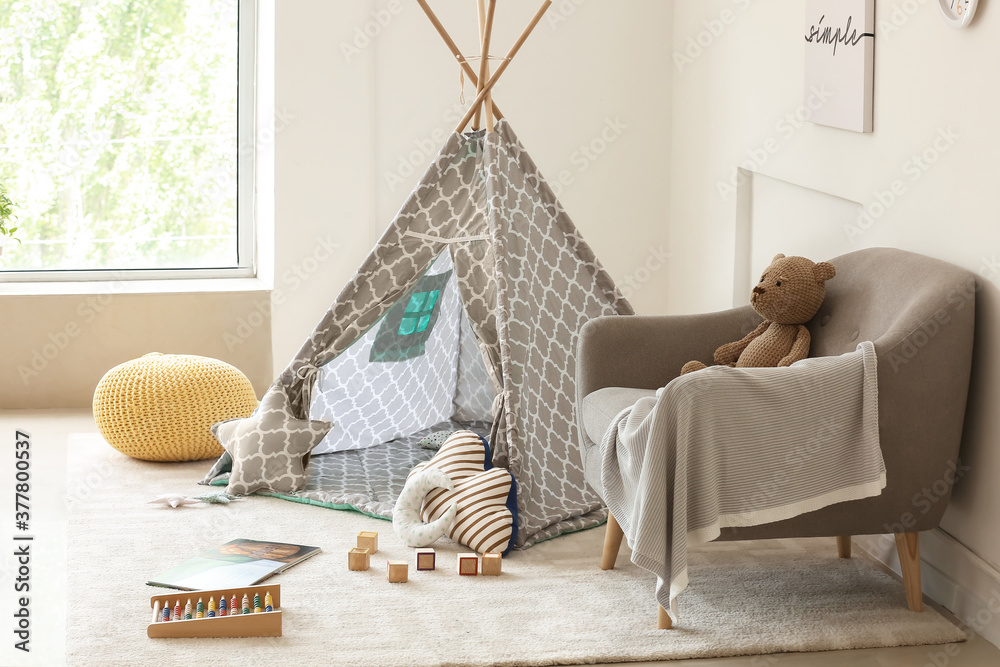 Interior of modern childrens room with play tent and toys