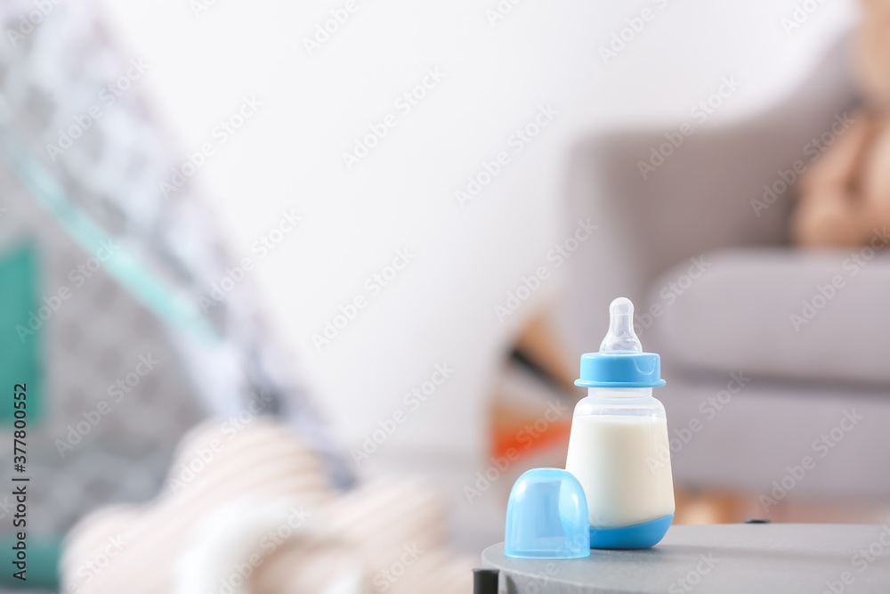 Bottle of milk for baby on table in room