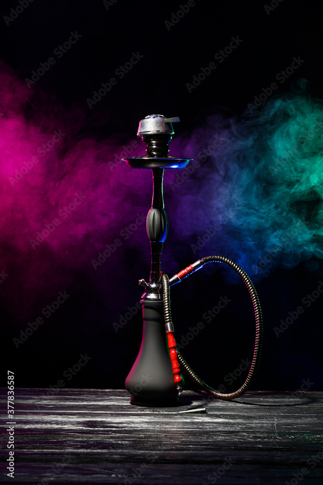 Hookah on table against dark background