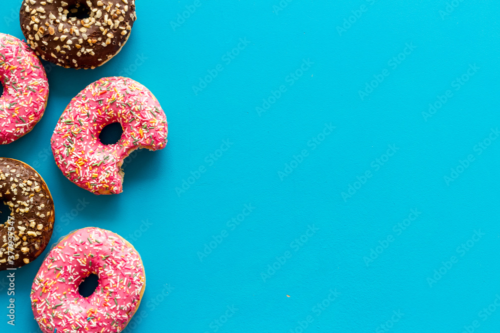 Colorful donuts pink and chocolate icing. Flat lay of bakery, above view