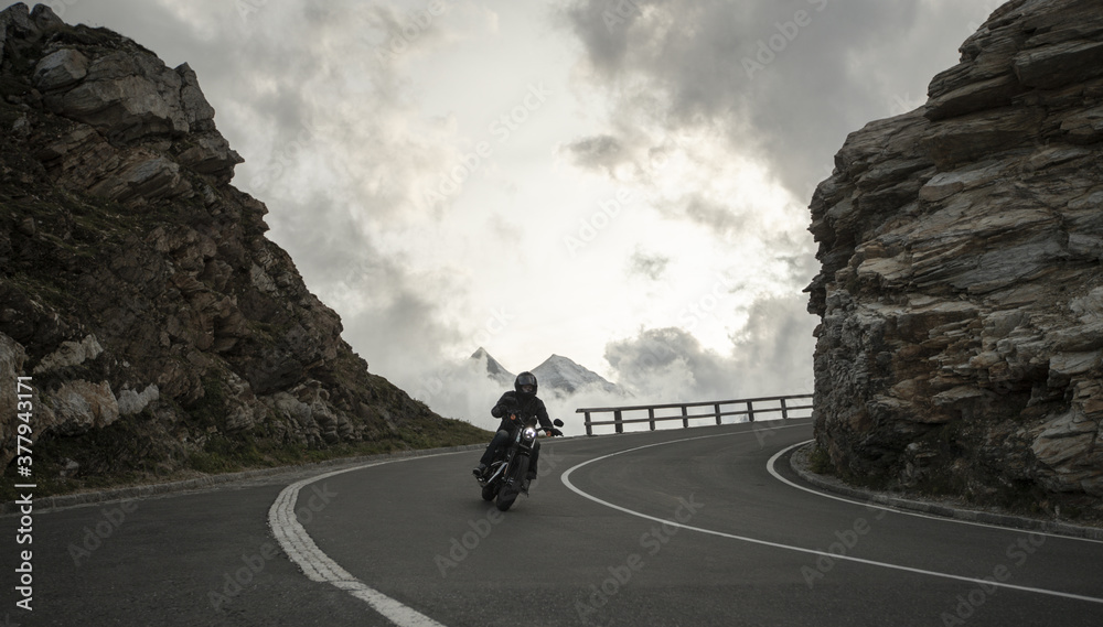 Motorcycle rider on the mountain road, between rocks.