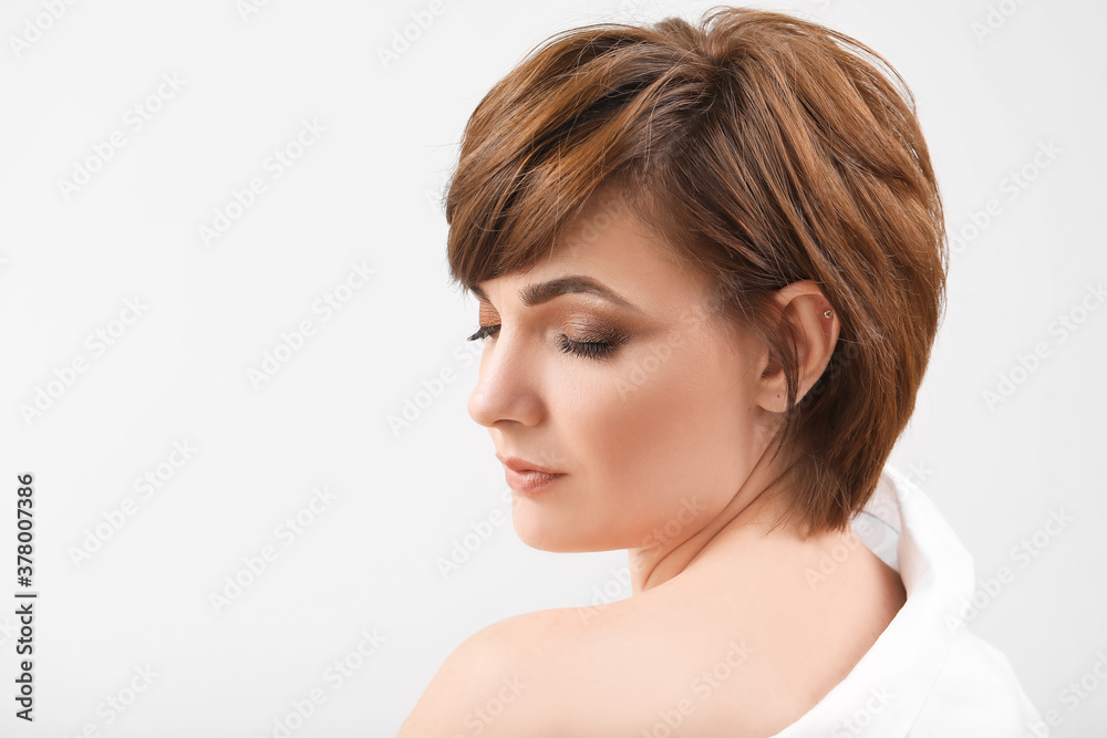 Young woman with beautiful short hair on grey background