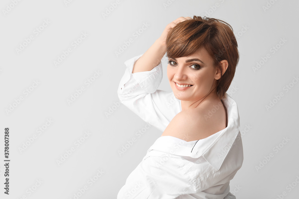 Young woman with beautiful short hair on grey background