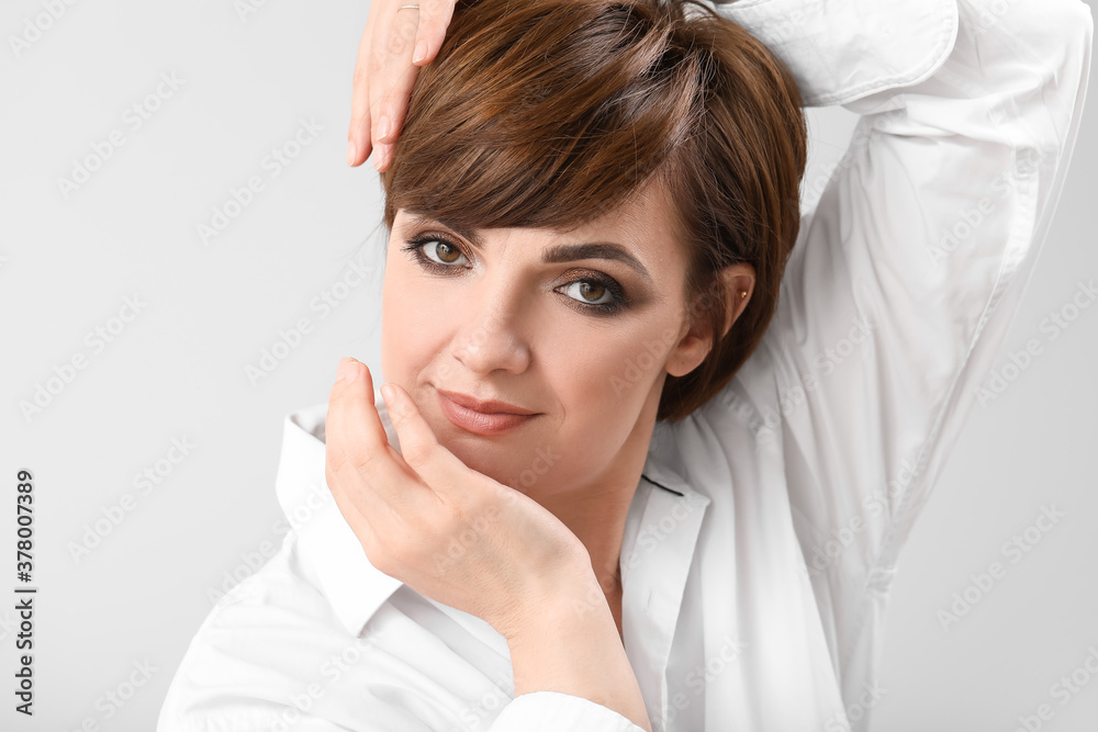 Young woman with beautiful short hair on grey background