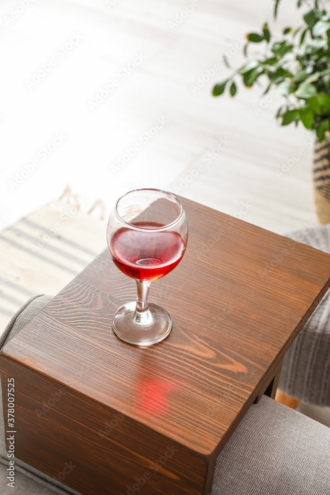 Glass of wine on armrest table in room