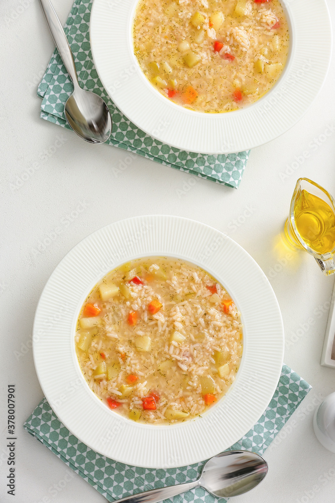 Bowls of tasty rice soup on white background