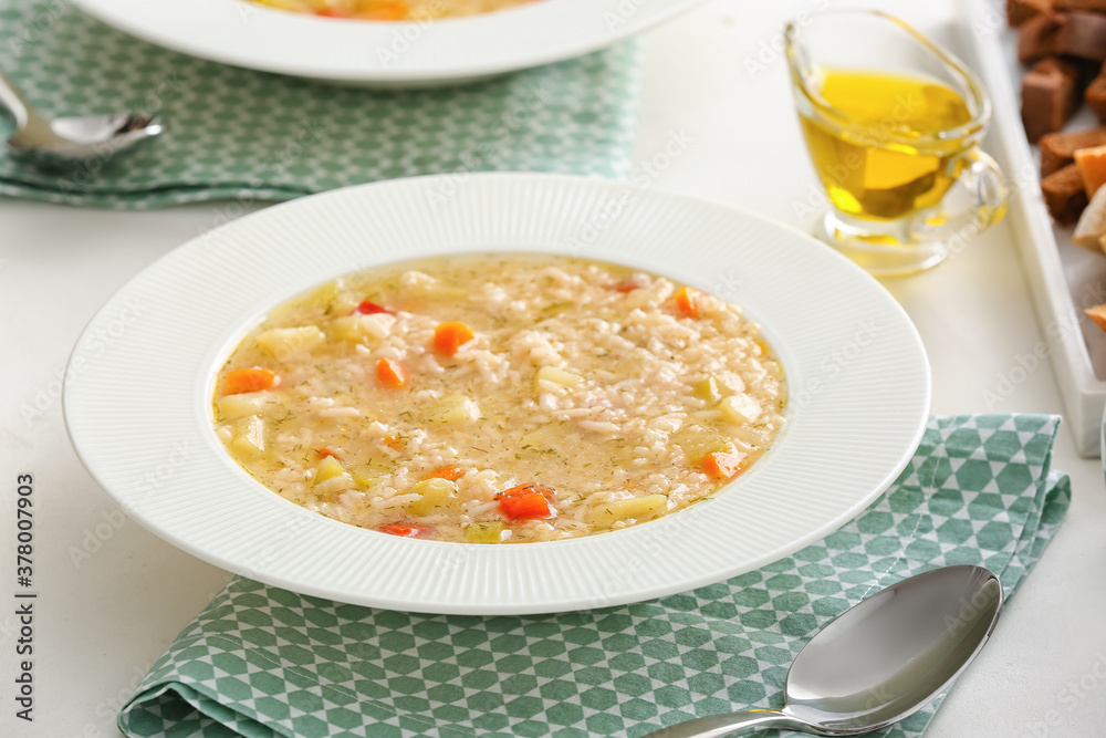 Bowl of tasty rice soup on table